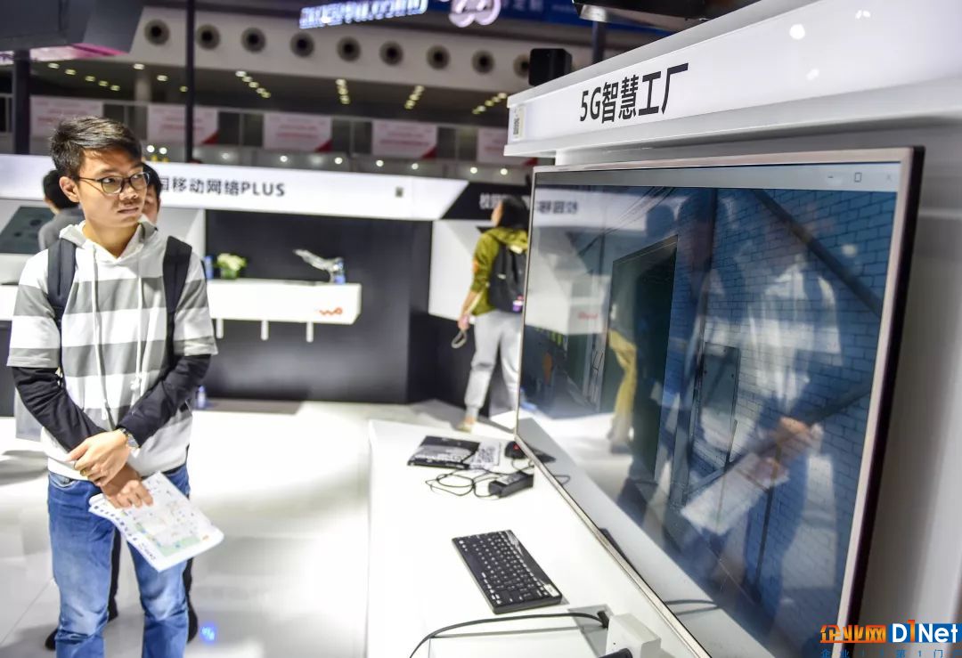 参观者在中国联通的展台观看5G智慧工厂模型
